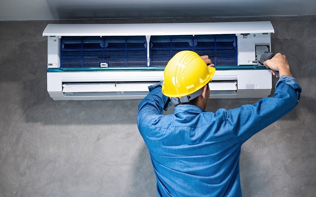 a person is repairing ac on wall